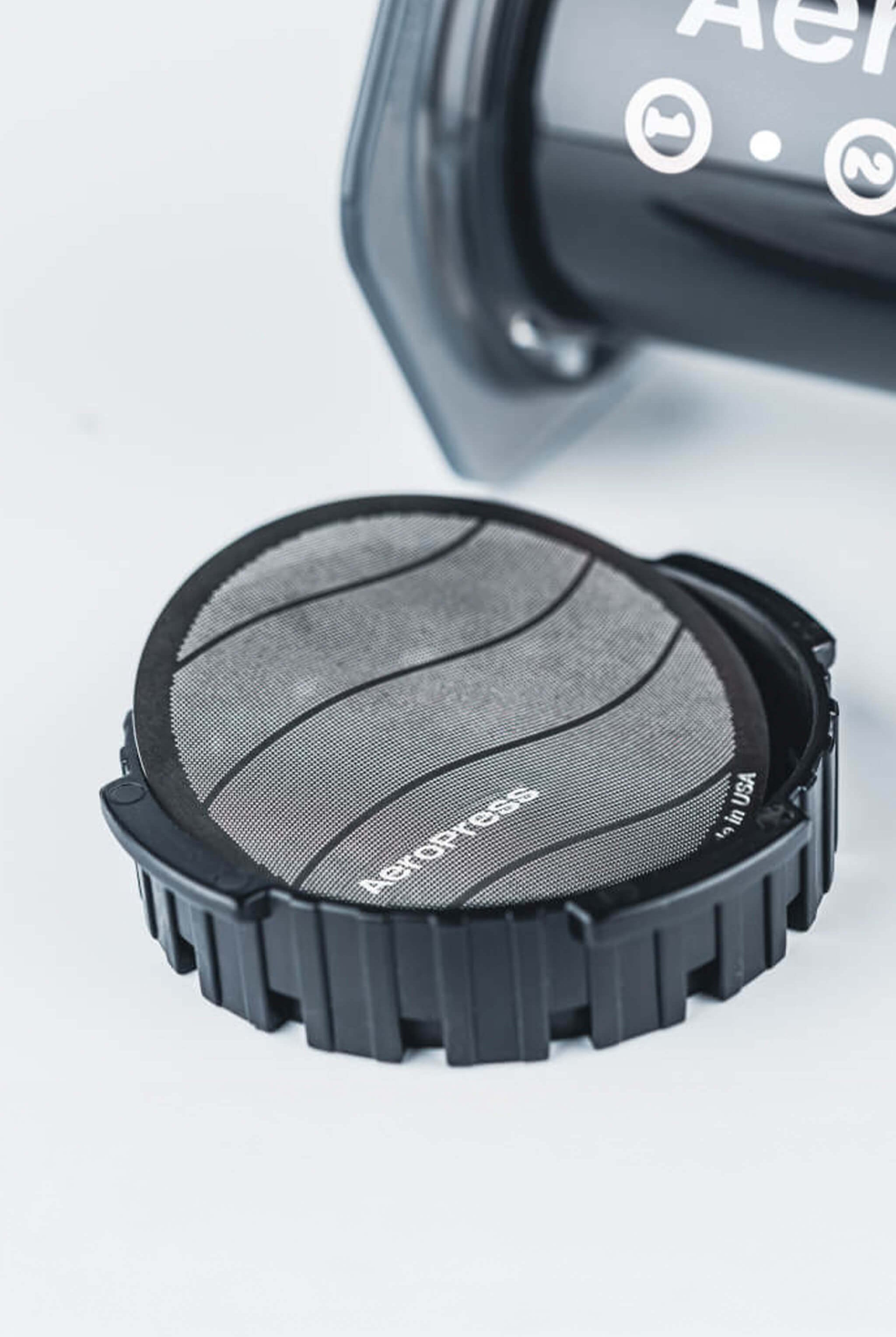 Aeropress coffee filter in cap on a white background