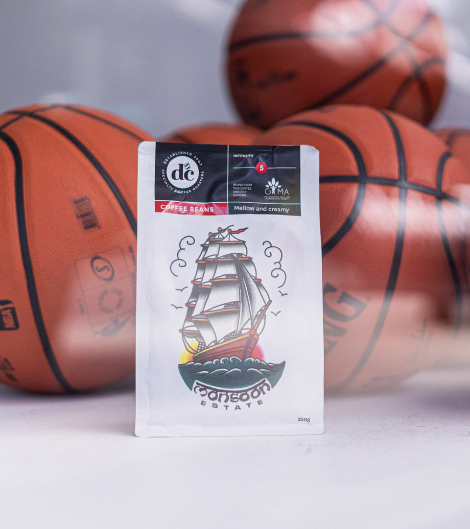 DC Coffee Monsoon Blend bag infront of basketballs