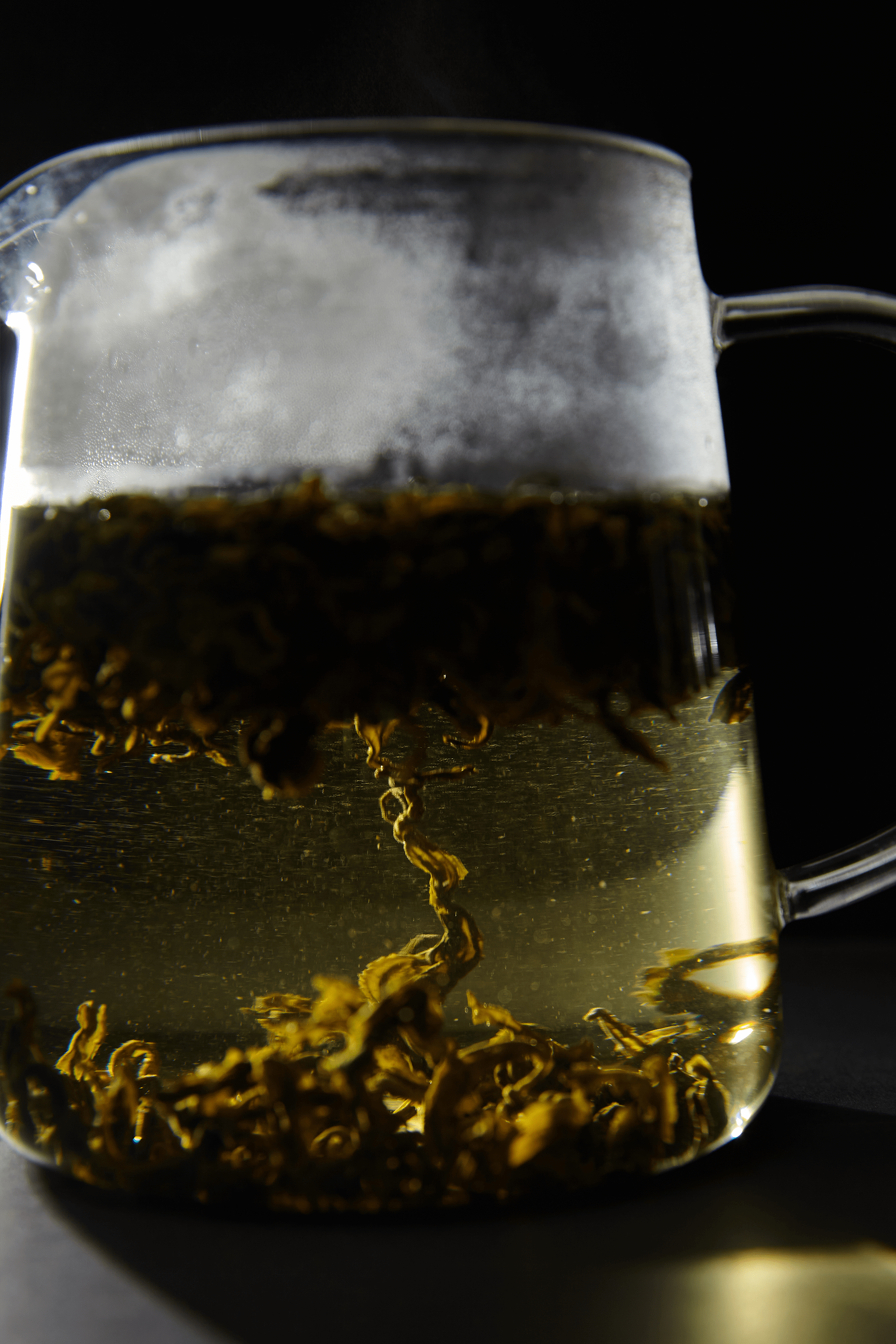 Tea leaves infusing in a glass pot