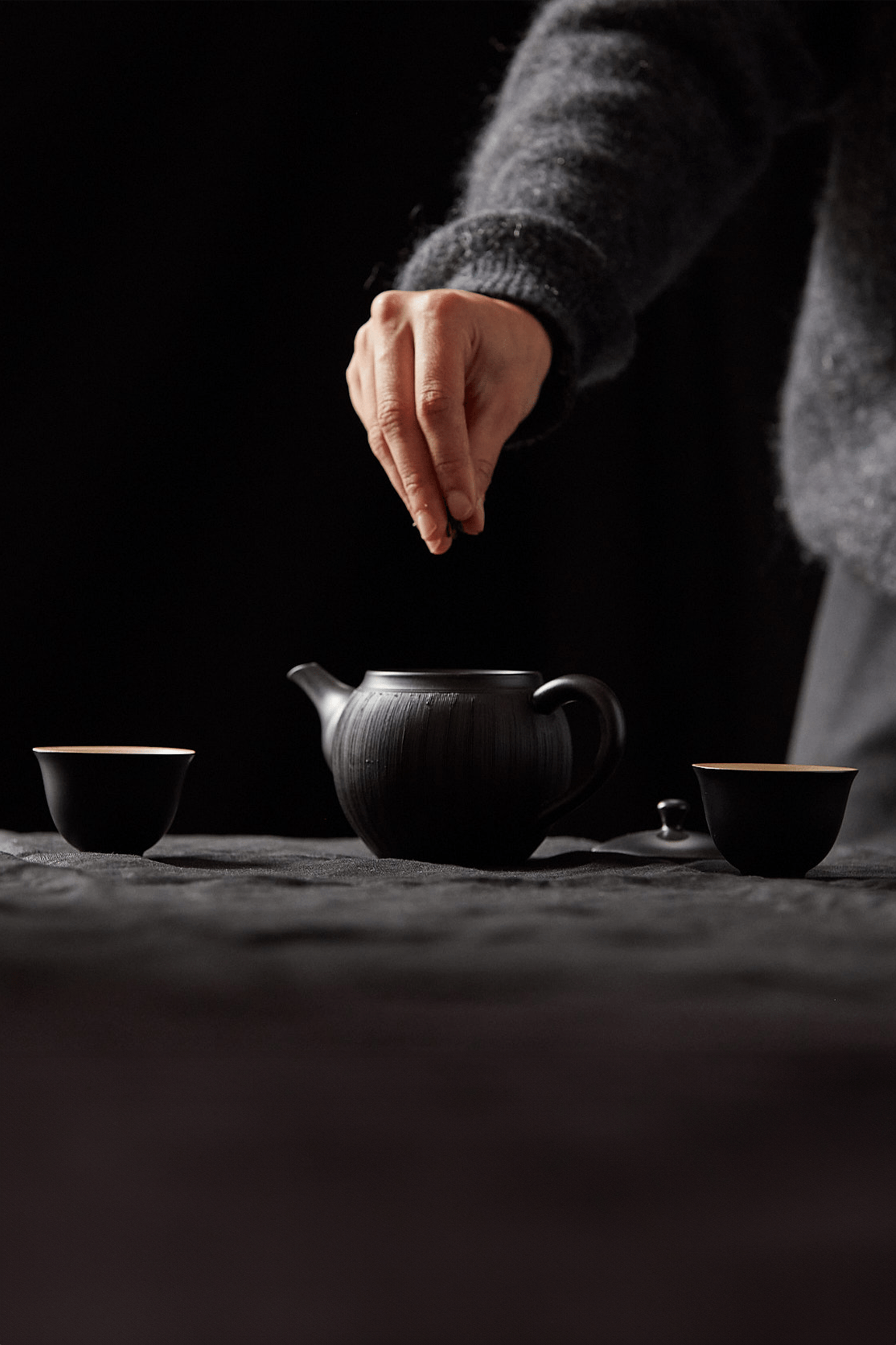 Tea leaves being dropped into a kettle