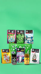 Collection of colorful coffee packages and jars on a green background
