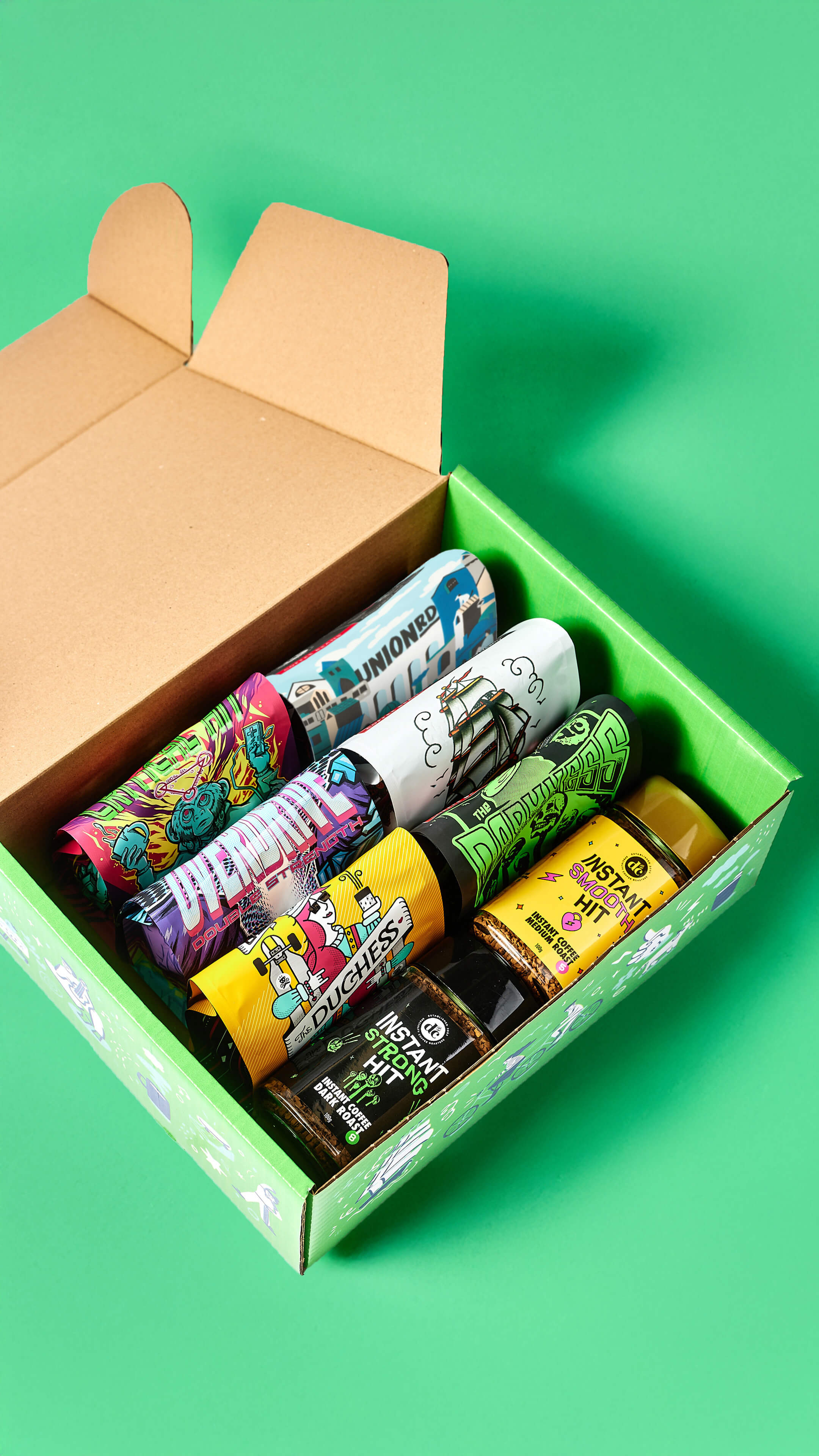 Open box with colourful coffee beans on a green background